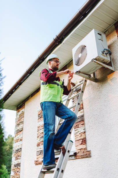 technician in uniform repairing heat pump